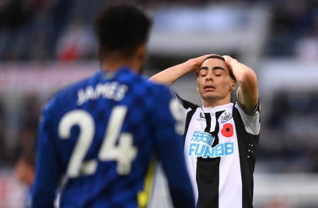 Miguel Almiron reacts dejectedly as Reece James of Chelsea looks on.