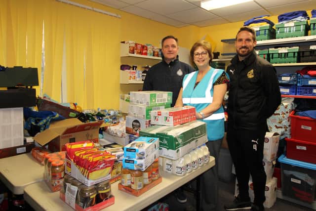 Food bank volunteer Adrienne Thompson with South Shields Football Club business development manager Colin Docherty, left, and captain Jon Shaw, right.