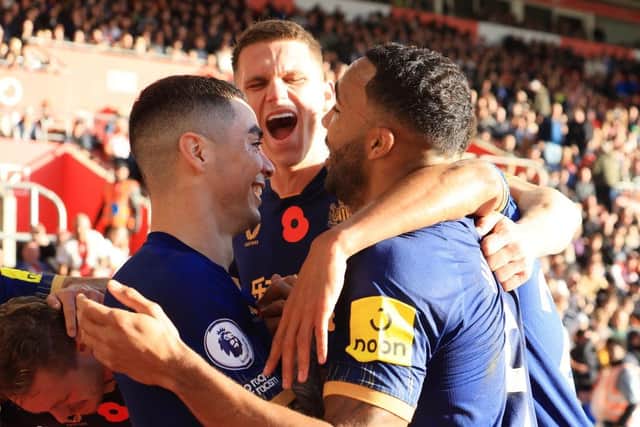 Newcastle United goalscorer Miguel Almiron celebrates with Callum Wilson, right, and Sven Botman, centre.