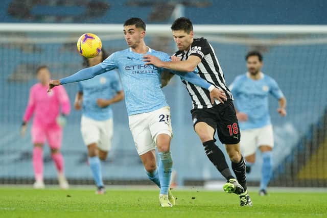 MANCHESTER, ENGLAND - DECEMBER 26: Ferran Torres of Manchester City holds off Federico Fernandez of Newcastle United during the Premier League match between Manchester City and Newcastle United at Etihad Stadium on December 26, 2020 in Manchester, England. The match will be played without fans, behind closed doors as a Covid-19 precaution. (Photo by Matt McNulty - Manchester City/Manchester City FC via Getty Images)