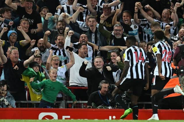 Newcastle United's Swedish striker Alexander Isak (2nd R) celebrates with fans after scoring the opening goal of the English Premier League football match between Liverpool and Newcastle United at Anfield in Liverpool, north west England on August 31, 2022.
