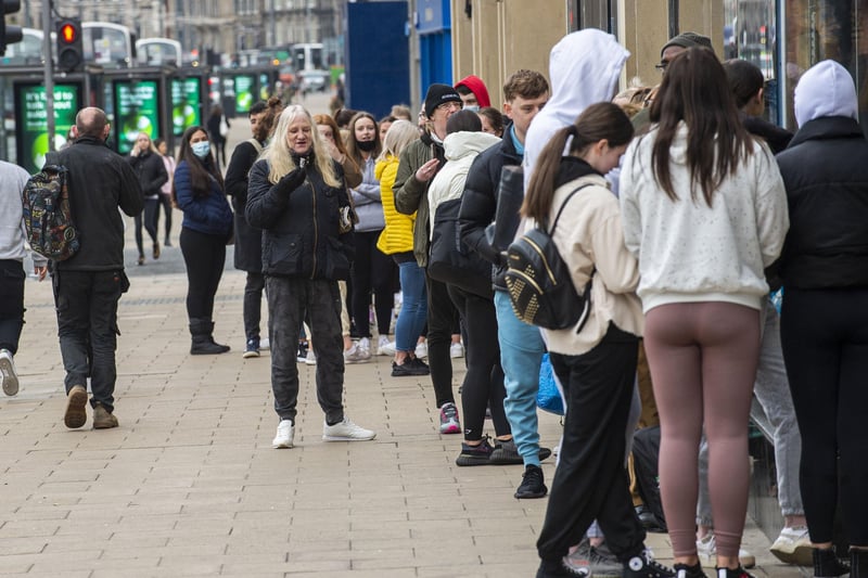 Edinburgh's Princes Street has been pictured filled with shoppers queuing outside shops as restrictions on non-essential retail lift across Scotland.