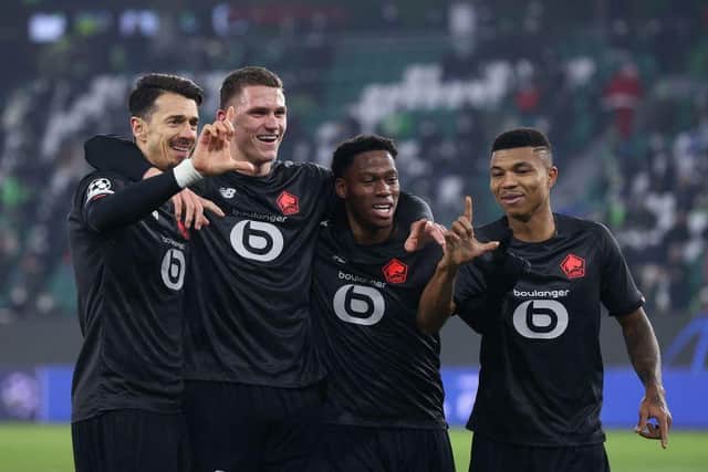 (L-R) Lille's Portuguese defender Jose Fonte, Lille's Dutch defender Sven Botman, Lille's Canadian forward Jonathan David and Lille's Mozambican defender Reinildo Mandava celebrate scoring during the UEFA Champions League group G football match VfL Wolfsburg v Lille LOSC in Wolfsburg, northern Germany on December 8, 2021. (Photo by RONNY HARTMANN/AFP via Getty Images)