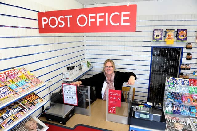 Madeline Duncan (54) at the Post Office counter inside of Duncan's News Hub.