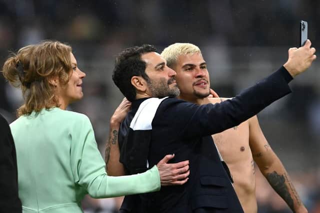 Newcastle United midfielder Bruno Guimaraes has a selfie with co-owners Amanda Staveley and Mehrdad Ghodoussi on the pitch after the Premier League match against Arsenal in May.