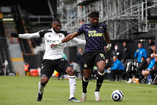 Allan Saint-Maximin of Newcastle United is challenged Andre-Frank Zambo Anguissa of Fulham by during the Premier League match between Fulham and Newcastle United at Craven Cottage on May 23, 2021 in London, England.