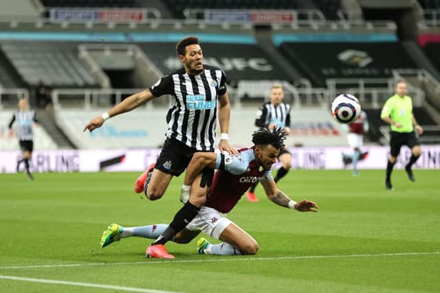 Tyrone Mings of Aston Villa is brought down by Joelinton of Newcastle United during the Premier League match between Newcastle United and Aston Villa at St. James Park on March 12, 2021 in Newcastle upon Tyne, England.