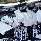 Newcastle United fans wave flags as they show their support prior to the Carabao Cup Final match between Manchester United and Newcastle United at Wembley Stadium. (Photo by Eddie Keogh/Getty Images).