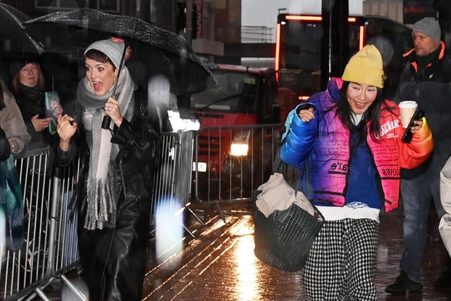 Dancers  Lauren Oakley and Nancy Xu arrive in the heavy rain.