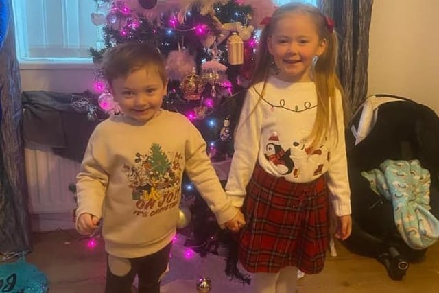Grayson and Harlow making memories by the Christmas tree.