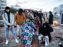 Earthquake survivors sit around a fire in Iskenderun Turkey