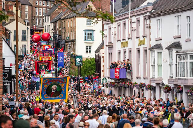 Crowds pass under the balcony of the County Hotel and along Old Elvet at the 2019 Durham Miners' Gala.