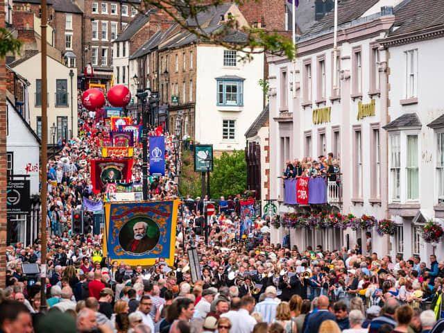 Crowds pass under the balcony of the County Hotel and along Old Elvet at the 2019 Durham Miners' Gala.