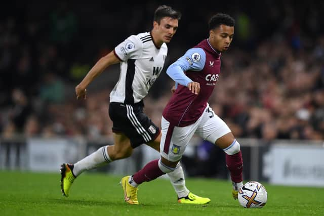 Cameron Archer of Aston Villa runs ahead of Joao Palhinha of Fulham during a Premier League match.