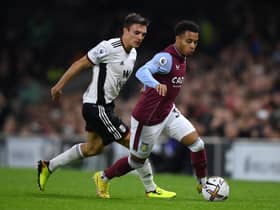 Cameron Archer of Aston Villa runs ahead of Joao Palhinha of Fulham during a Premier League match.
