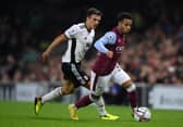 Cameron Archer of Aston Villa runs ahead of Joao Palhinha of Fulham during a Premier League match.