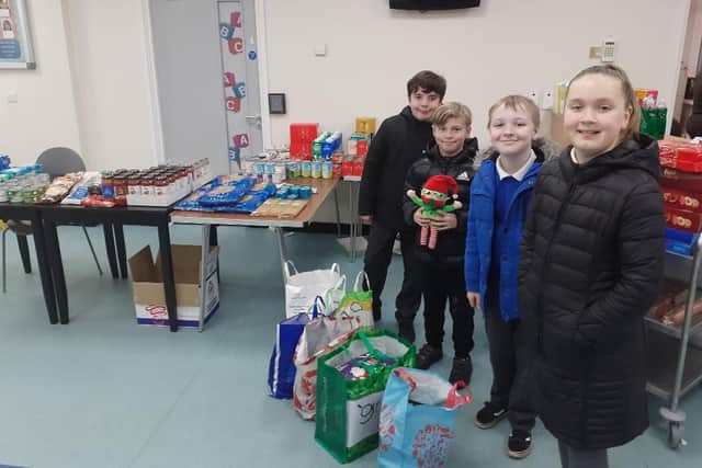 Pupils from Fellgate Primary's 'Plums' group present goodies at Hedworthfield CA. From left, Oliver, Logan, Harry and Emma, with Buddy the elf.