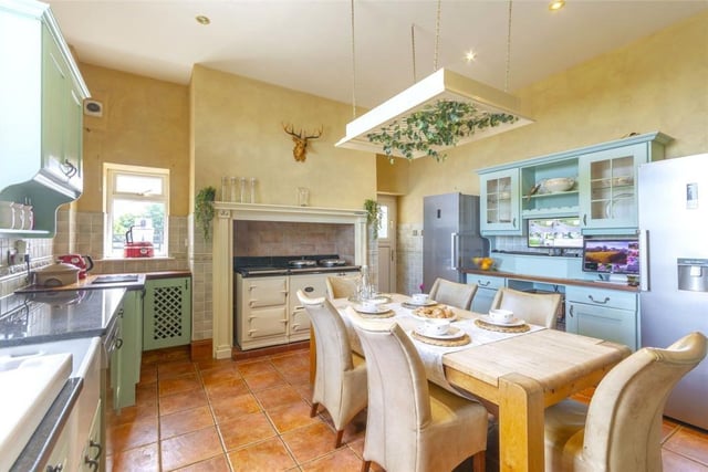 The spacious kitchen with ample space for a dining table leads to a sunroom.