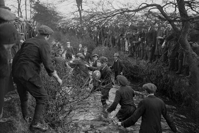 Players tussling for the ball in the brook during the Royal Shrovetide Football Match, Ashbourne in 1926. The game is still played annually on Shrove Tuesday and Ash Wednesday and is similar to medieval versions of football. (Photo by E. Bacon/Topical Press Agency/Hulton Archive/Getty Images)