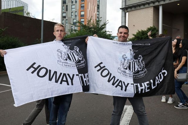 Two fans pose with flags as they make their way into the stadium (Photo by Clive Brunskill/Getty Images)