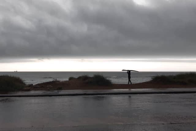 A surfer braves the waves at Sandhaven Beach, in South Shields, despite the wet and windy weather.