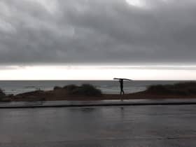 A surfer braves the waves at Sandhaven Beach, in South Shields, despite the wet and windy weather.