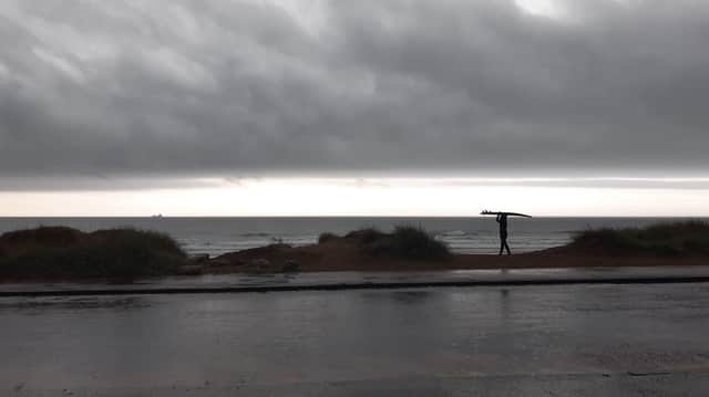 A surfer braves the waves at Sandhaven Beach, in South Shields, despite the wet and windy weather.