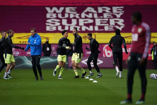 Newcastle United's English-born Northern Irish defender Jamal Lewis (C-L) and Newcastle United's English striker Andy Carroll (C-R) warm up prior to the English Premier League football match between Burnley and Newcastle United at Turf Moor in Burnley, north west England on April 11, 2021.