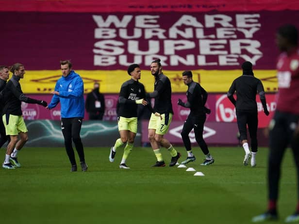 Newcastle United's English-born Northern Irish defender Jamal Lewis (C-L) and Newcastle United's English striker Andy Carroll (C-R) warm up prior to the English Premier League football match between Burnley and Newcastle United at Turf Moor in Burnley, north west England on April 11, 2021.