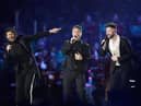 Howard Donald and Gary Barlow of Take That, perform with Callum Scott (right) on stage during the Coronation Concert