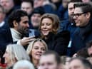 Newcastle United's owners Amanda Staveley (C) looks at her husband Mehrdad Ghodoussi's (L) phone, ahead of the English Premier League football match between Newcastle United and Fulham at St James' Park in Newcastle-upon-Tyne, north-east England on January 15, 2023. (Photo by OLI SCARFF/AFP via Getty Images)