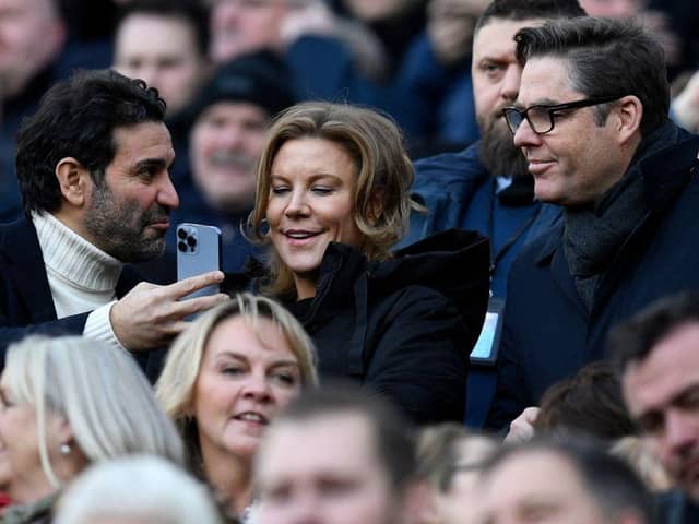 Newcastle United's owners Amanda Staveley (C) looks at her husband Mehrdad Ghodoussi's (L) phone, ahead of the English Premier League football match between Newcastle United and Fulham at St James' Park in Newcastle-upon-Tyne, north-east England on January 15, 2023. (Photo by OLI SCARFF/AFP via Getty Images)