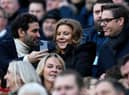 Newcastle United's owners Amanda Staveley (C) looks at her husband Mehrdad Ghodoussi's (L) phone, ahead of the English Premier League football match between Newcastle United and Fulham at St James' Park in Newcastle-upon-Tyne, north-east England on January 15, 2023. (Photo by OLI SCARFF/AFP via Getty Images)