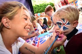 2 year old Noah Cutting has his face painted by Jade Benton from "Brush Hour"