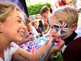 2 year old Noah Cutting has his face painted by Jade Benton from "Brush Hour"