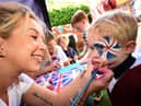 2 year old Noah Cutting has his face painted by Jade Benton from "Brush Hour"