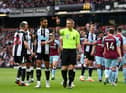 Craig Pawson indicates a VAR review for a penalty for Newcastle United during the Premier League match between Burnley and Newcastle United at Turf Moor on May 22, 2022 in Burnley, England. (Photo by Gareth Copley/Getty Images)