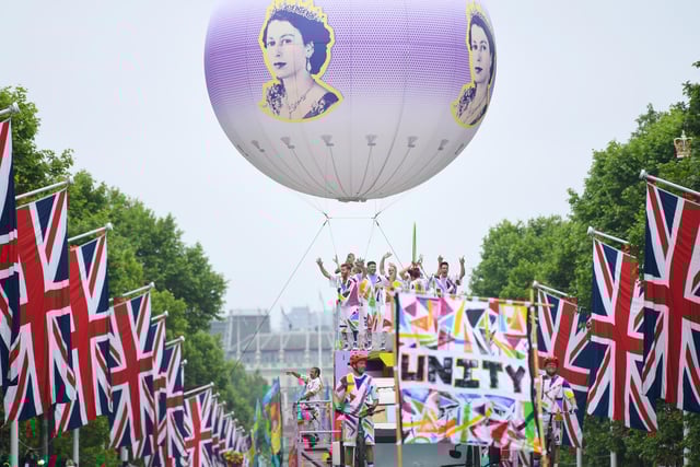 A balloon bearing the Queens' face makes its way down The Mall