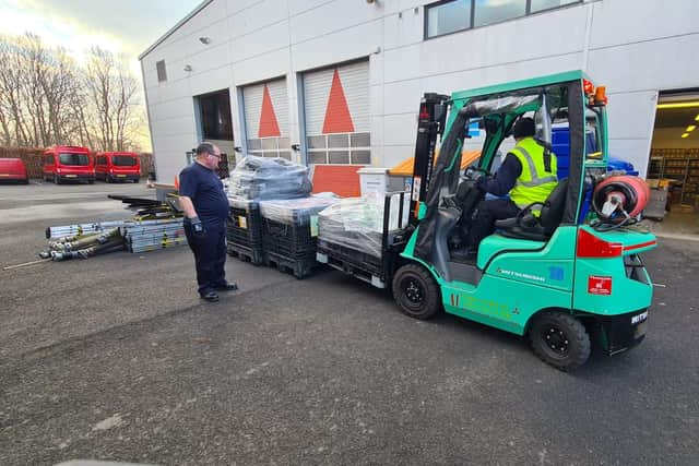 Staff at Tony Carter Transport Limited loading fire equipment onto lorry at TWFRS Stores warehouse