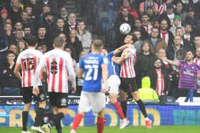 Sunderland's Tom Flanagan, right, gets the better of Portsmouth's John Marquis in this aerial battle - but Marquis had the last laugh.