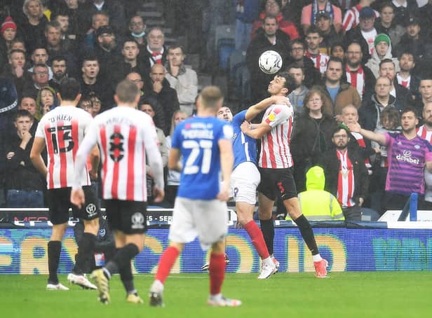 Sunderland's Tom Flanagan, right, gets the better of Portsmouth's John Marquis in this aerial battle - but Marquis had the last laugh.