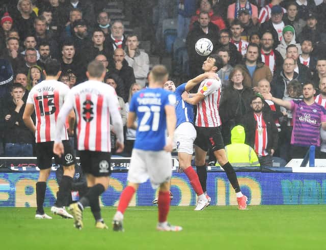 Sunderland's Tom Flanagan, right, gets the better of Portsmouth's John Marquis in this aerial battle - but Marquis had the last laugh.