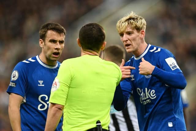 Referee Tony Harrington is confronted by Everton captain Seamus Coleman and Anthony Gordon.