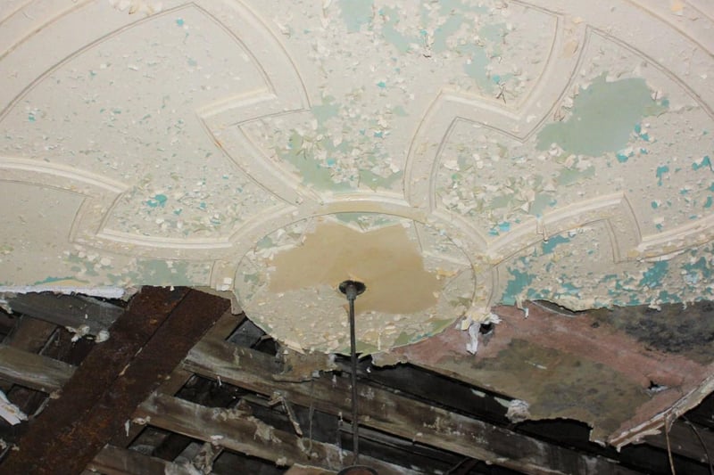 "Today the circled ceiling plaster only half exists. The rest fallen to the ground at the bottom of the staircase. Only part of a snapped wire exists from the hanging light. Through the peeling paint you can see the cream paint has peeled and revealed an original colour underneath, an off green."