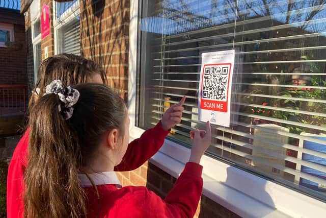 Children from St Joseph's Catholic Primary School with one of the QR codes.