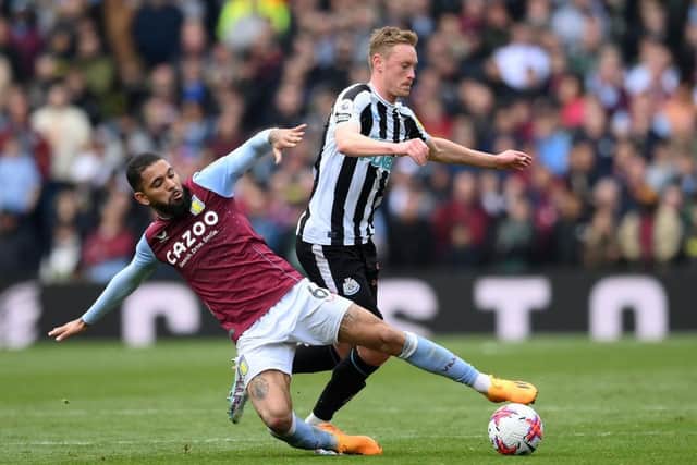 Sean Longstaff of Newcastle United is tackled by Douglas Luiz of Aston Villa during the Premier League match between Aston Villa and Newcastle United at Villa Park on April 15, 2023 in Birmingham, England. (Photo by Shaun Botterill/Getty Images)