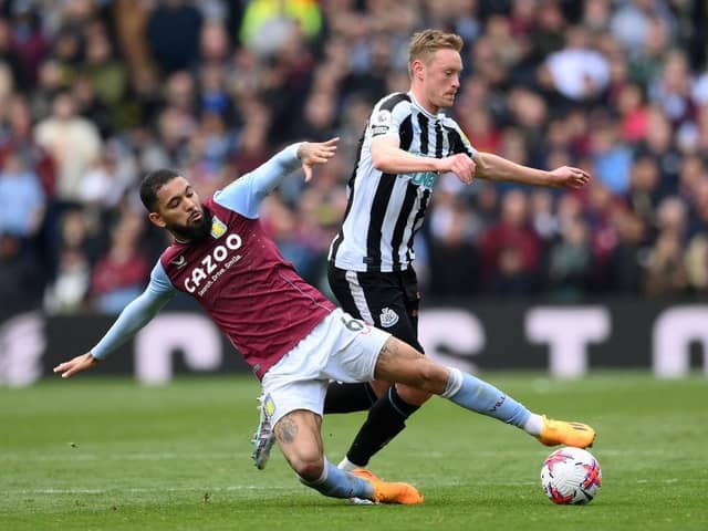Sean Longstaff of Newcastle United is tackled by Douglas Luiz of Aston Villa during the Premier League match between Aston Villa and Newcastle United at Villa Park on April 15, 2023 in Birmingham, England. (Photo by Shaun Botterill/Getty Images)