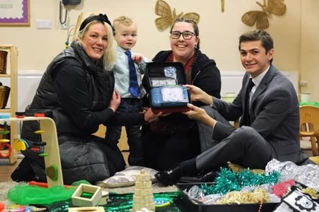 Alexandra Maria Dellorusso, with son Emerald, nursery worker Laura Phipps and Cllr Ellison with the defibrillator.