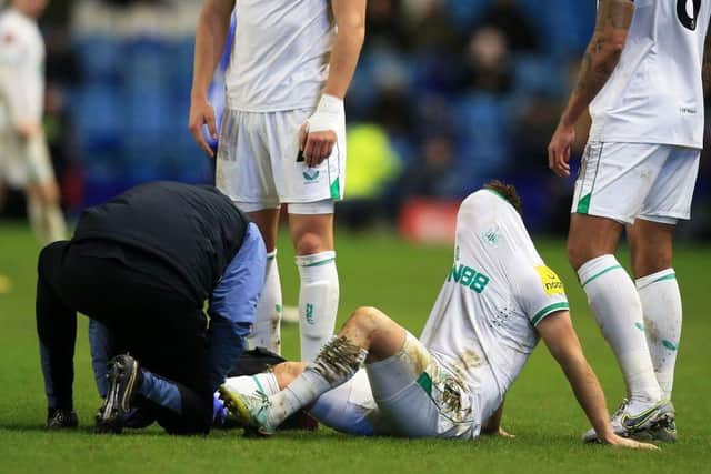 Newcastle United's Scottish midfielder Matt Ritchie receives medical treatment during the English FA Cup third round football match between Sheffield Wednesday and Newcastle United at Hillsborough Stadium in Sheffield, northern England on January 7, 2023. (Photo by LINDSEY PARNABY/AFP via Getty Images)