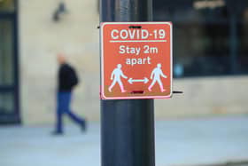 File photo of a sign advising people to stay two metres apart on a lamppost